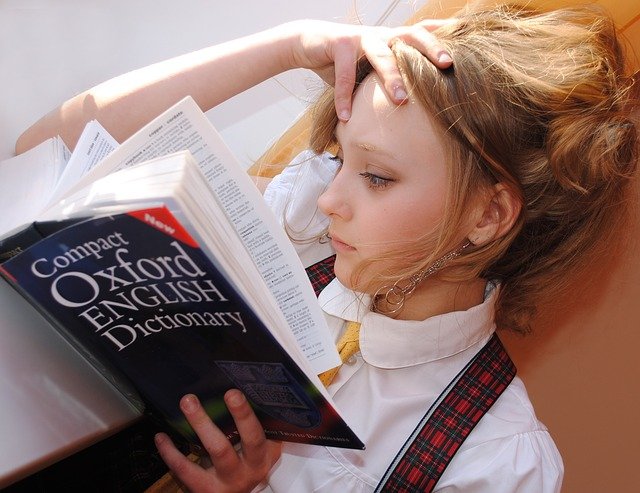 Criança estudando idiomas com um dicionário